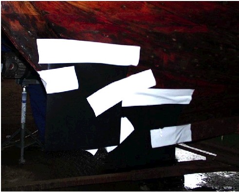 Figur 42. Bagbord side af stævn med folieplader påhæftet skibet. (pladerne er sorte, tapen er hvid)