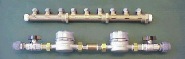 <strong>Figur 5.</strong>Eksempler på sammenkoblede testemner fra forsøgsperioden 2002-2003 eksponeret på Lysholt Vandværk. Øverst ses fordelerrør af afzinkningsbestandig messing, A-metal, emne 17/18. Nederst ses vandmåler med afspærringsventil og fittings, emne 19/20. Dette emne indeholder både almindelig messing og DZR-messing. Måler og ventil er forniklet