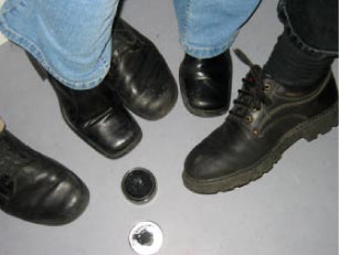 Foto: En åben dåse skosværte omgivet af flere par sko