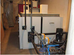 Figur 24: Anlægget set fra bagsiden. Trykrør til den kondensatoren ses på billedet sammen med de 2 hovedpumper på anlægget. Pumperne forsyner dels fan-coils på kontorer og down flow units i serverrum med koldt vand.