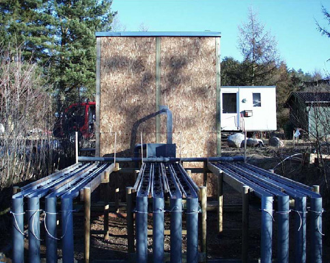 Figur 2.3. Foto af fors&oslash;gsopstillingen med de 12 vandl&oslash;bsrender. Driftnettene er placeret i de lodrette nedl&oslash;bsr&oslash;r forrest i billedet