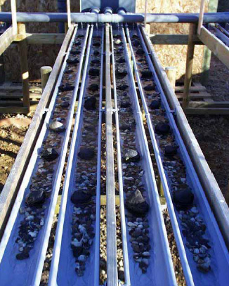 Figur 2.4. Foto af de 3 meter lange substrat-str&aelig;kninger best&aring;ende af grus, sten og elleblade