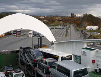 Figure 7­1 The gas fuelled ferries Bergensfjord, Fanafjord and Raunafjord operating between Halhjem and Sandvikvåg have two LNG tanks onboard of 125 m³ each. For bunkering, two LNG tanks of 500 m³ each are located on the quay at Halhjem (right). These tanks are refilled by a LNG carrier or trucks (Photo courtesy of DNV)