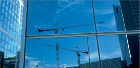 Kraner spejler sig i glasfacade